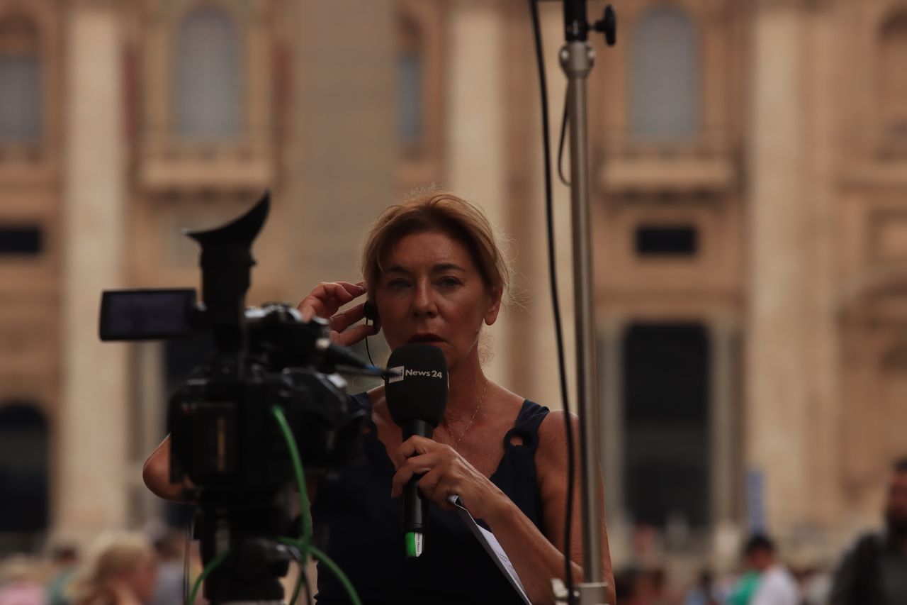 Journalist reporting live from Vatican City, capturing the essence of urban broadcast journalism.
